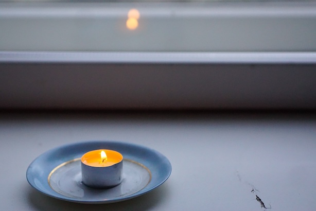 Ikkunanlaudalla palava tuikkukynttilä