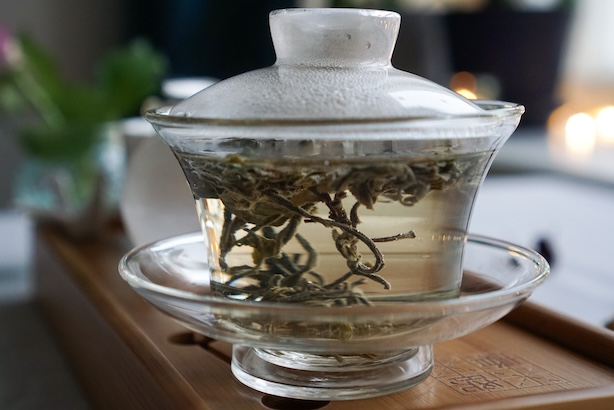 Kuva gaiwanissa hautuvista vihreistä teenlehdistä