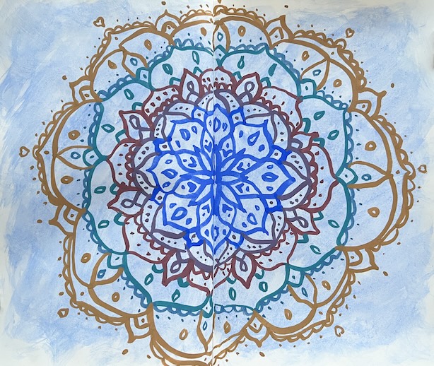 Sinisielle taustalle maalattu monivärinen mandala