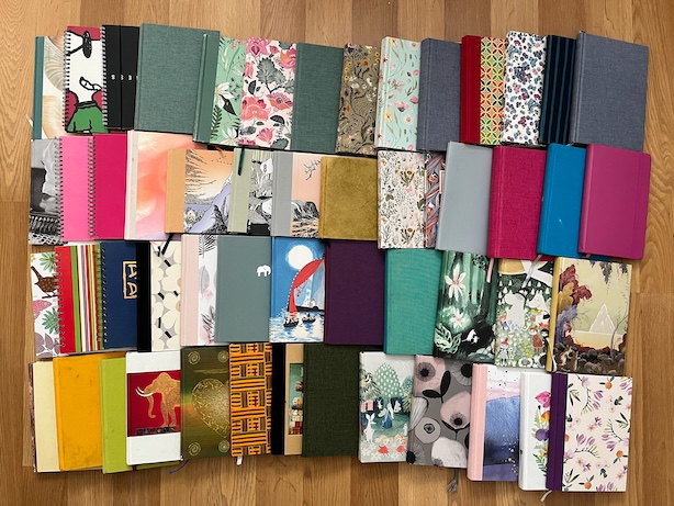 Valokuva lattialle levitetyistä päiväkirjoista.